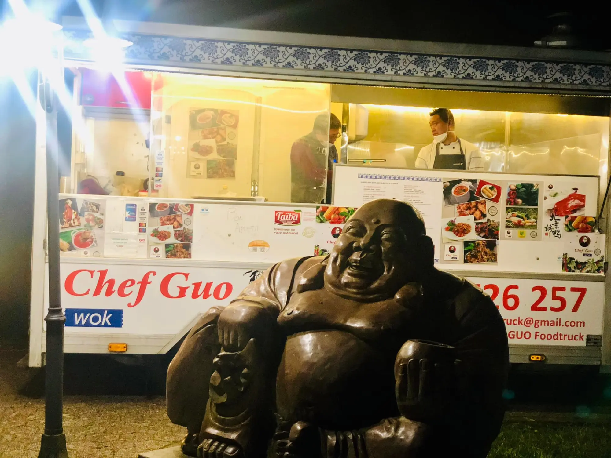 Black statue of a happy man in front of the foodtruck