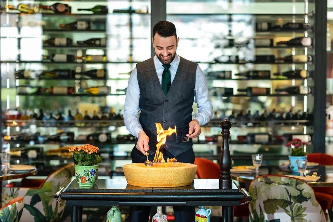 Italian restaurant, man cooking pasta in cheese traditional Italian cuisine