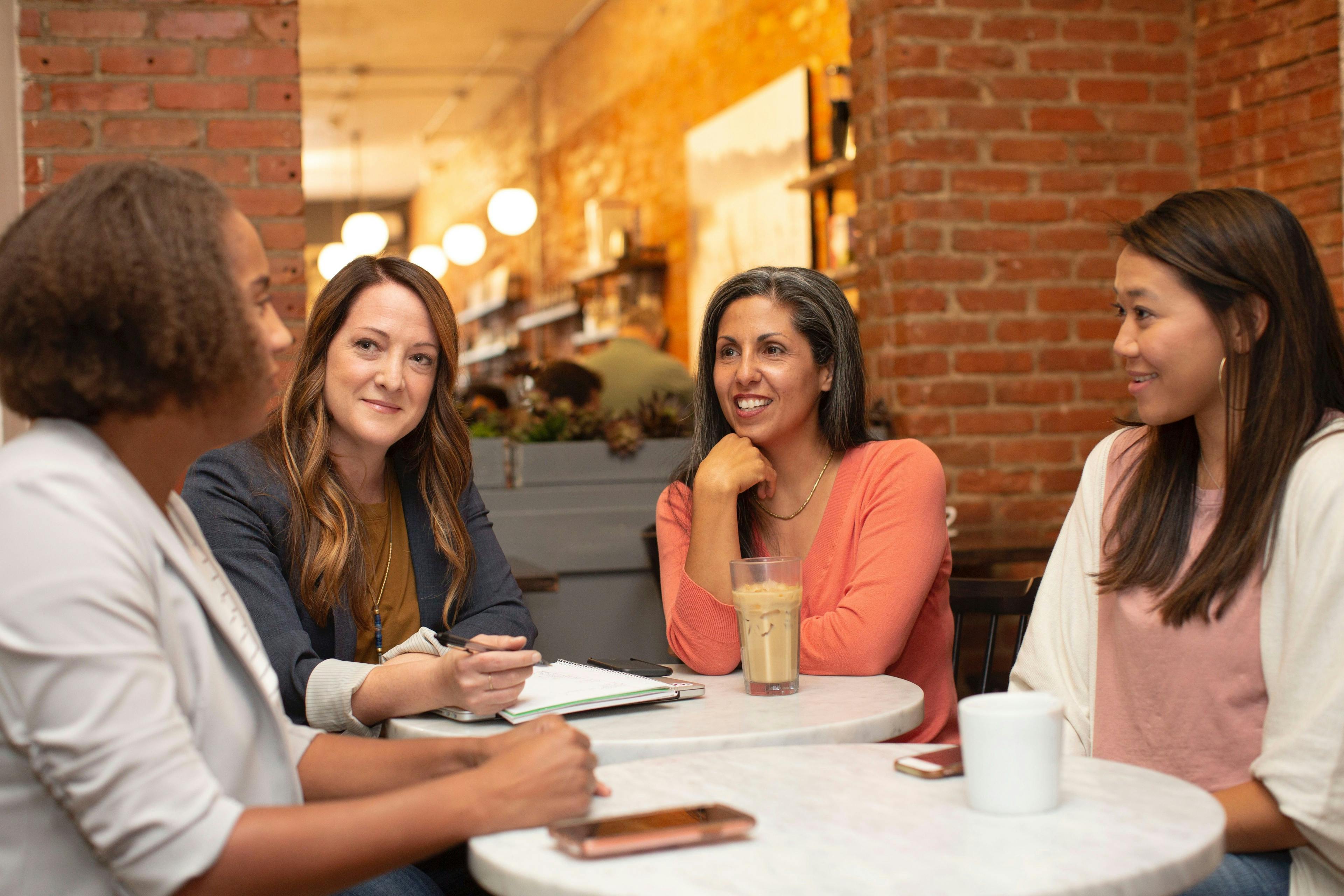 Четыре женщины разговаривают в кафе, столики, кофе